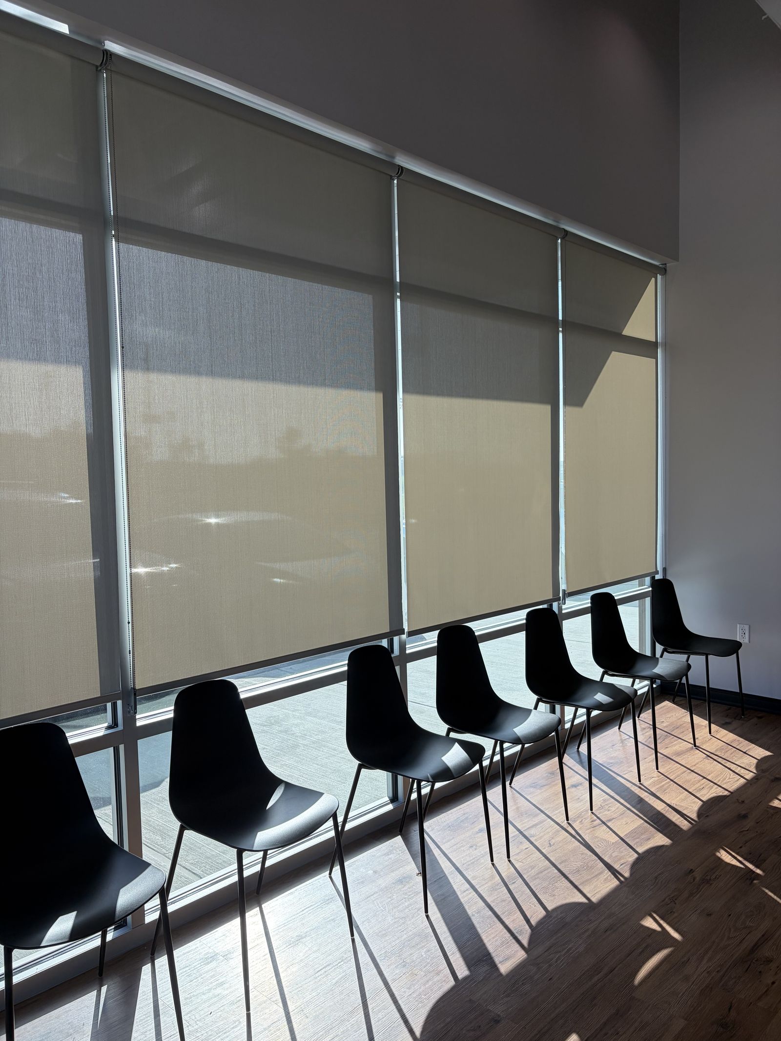 Hunter Douglas Architectural roller shades over windows in a commercial waiting room.