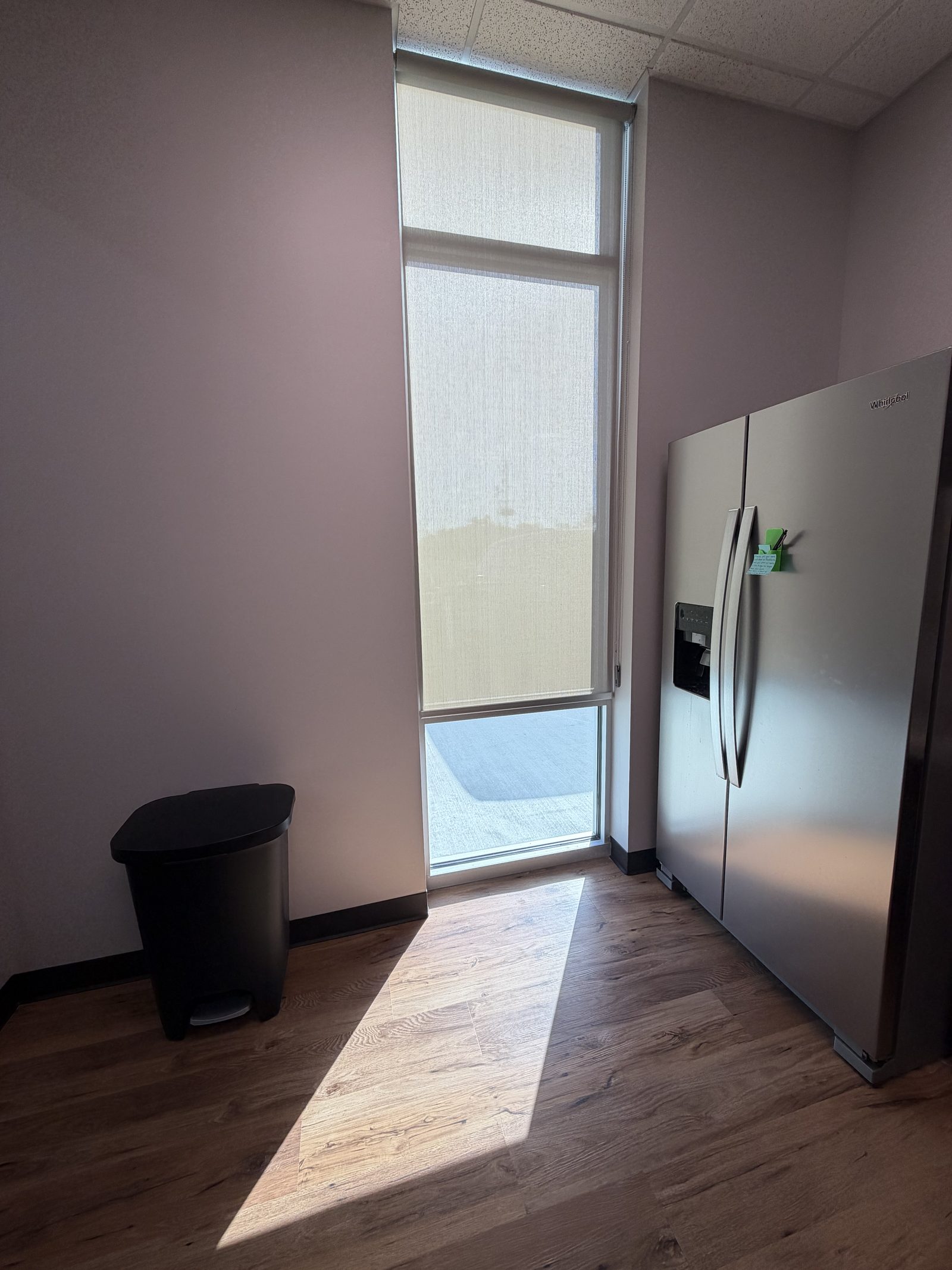 Solar screen roller shade on a tall narrow window at the TrueAnimalVet Grand Oaks location on Riley Fuzzel in Spring, TX, cutting glare while keeping daylight