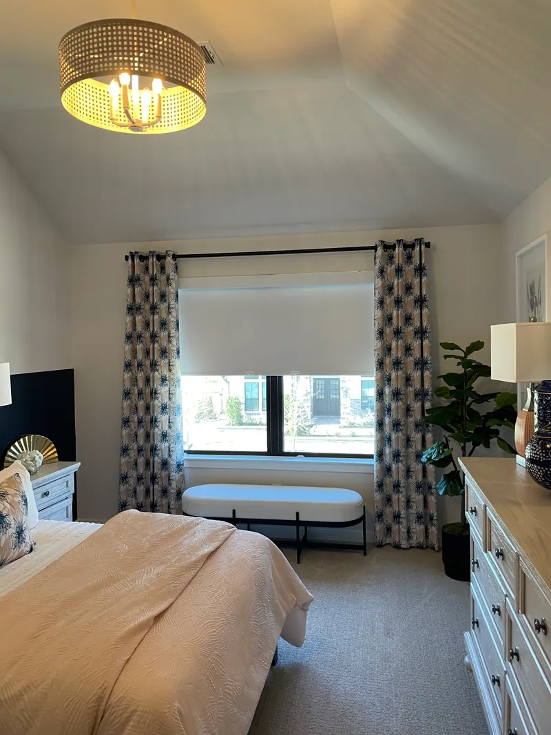 Blackout roller shade covering a guest-bedroom window.