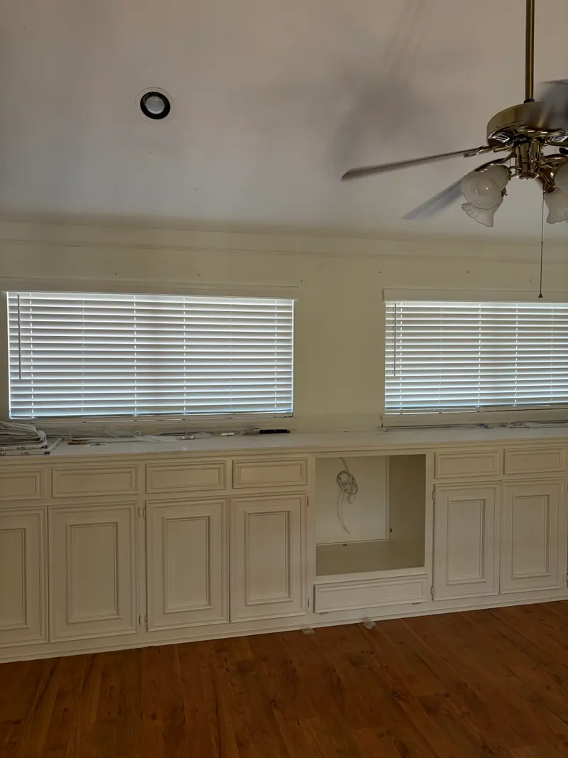 White faux wood blinds over game-room windows.