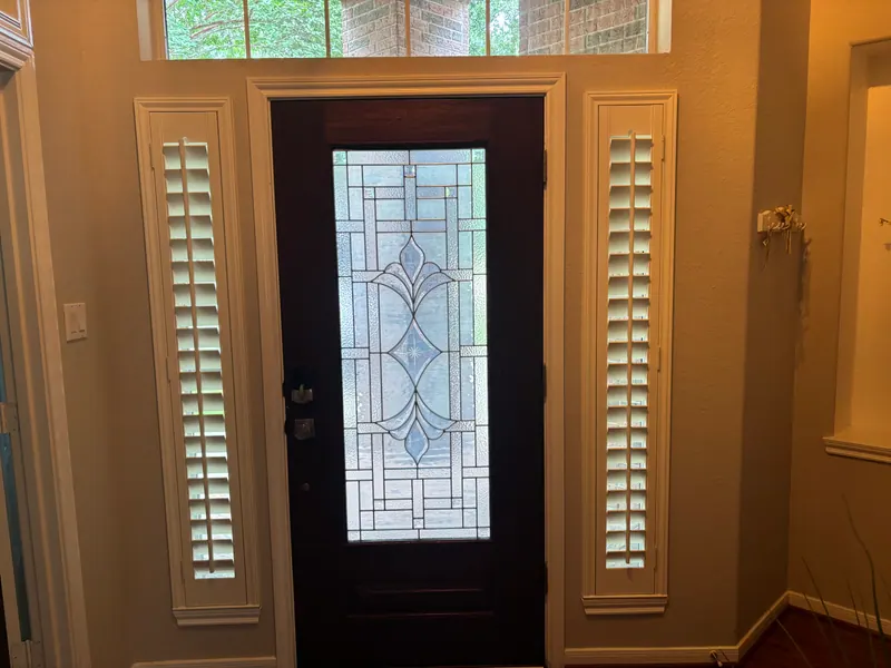 White plantation shutters at an entryway window.