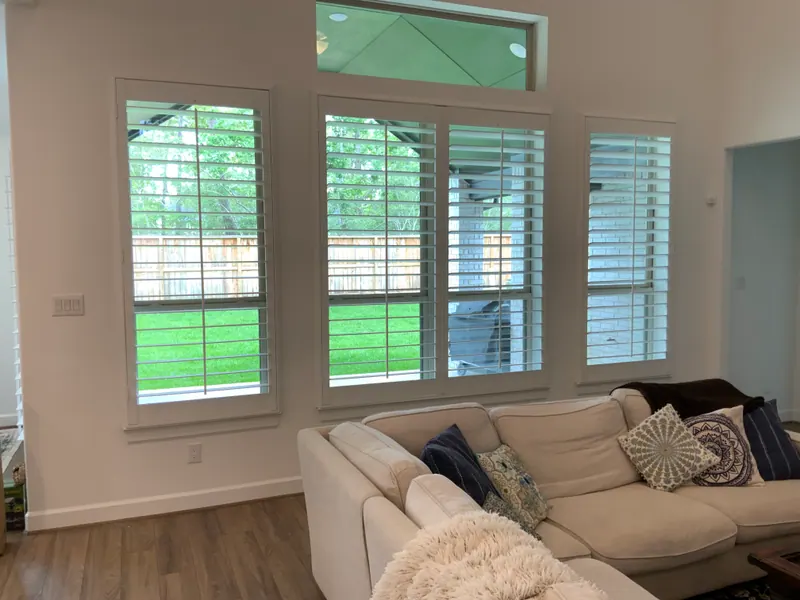 White plantation shutters covering living-room windows.