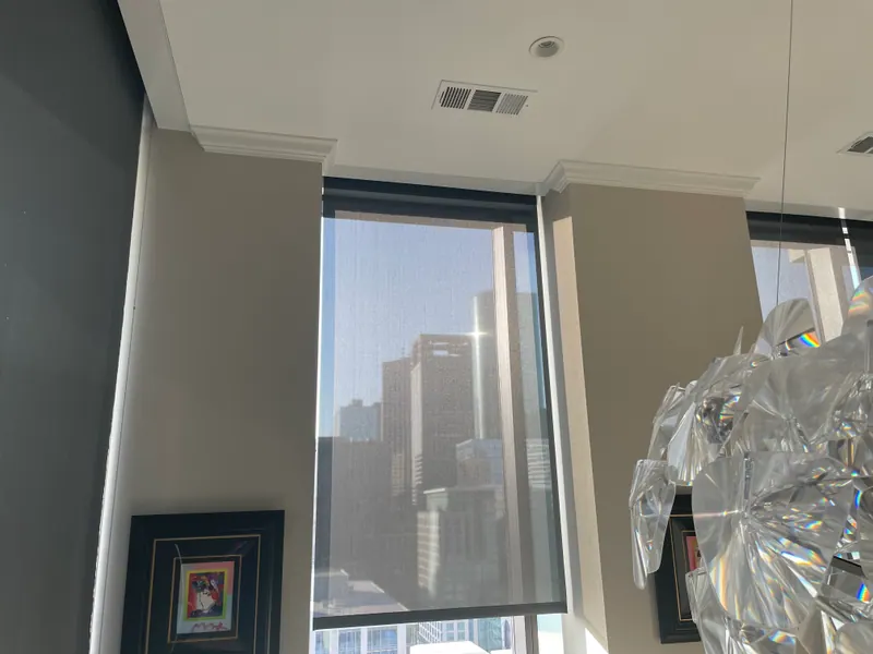 Roller shade lowered over an apartment kitchen window.