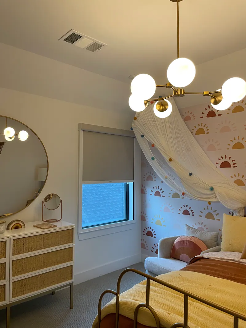 Blackout roller shade lowering over a bedroom window.