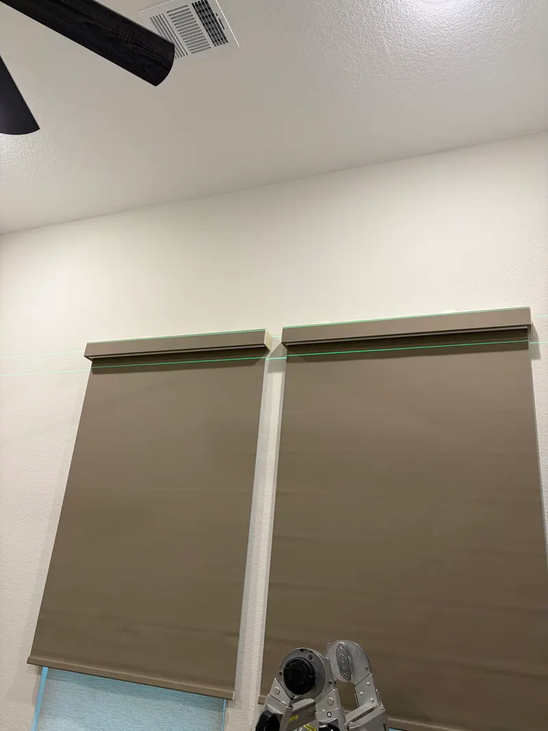 Roller shades over a pair of bedroom windows.