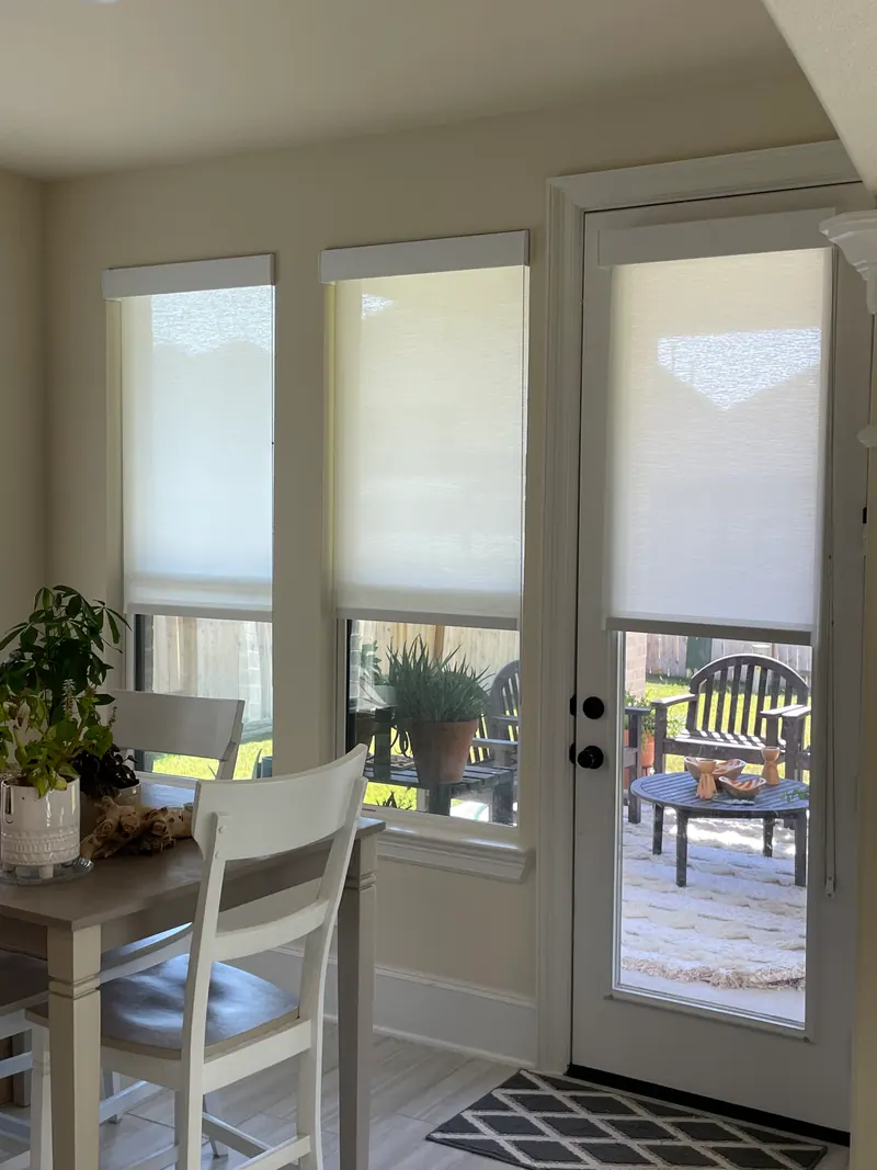 Light-colored roller shades over breakfast-area windows.