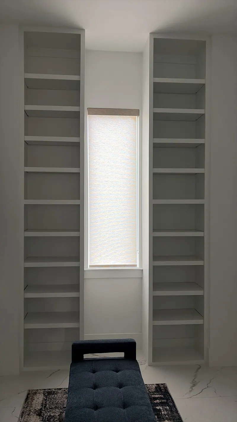White roller shades over corner windows in a living room.