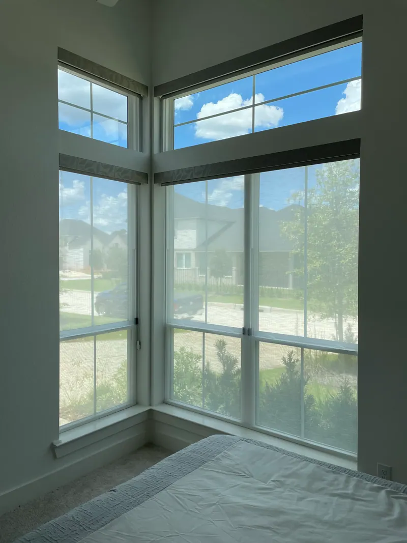 Sheer and blackout roller shades at a guest-bedroom window.