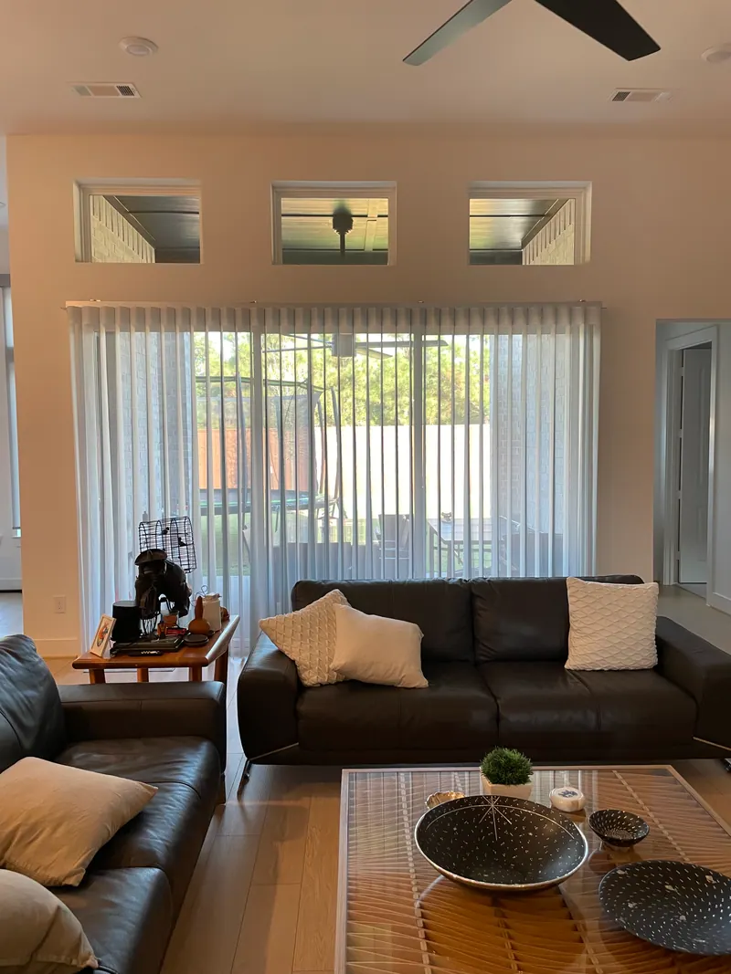 SmartDrapes hanging across a living-room sliding glass door.